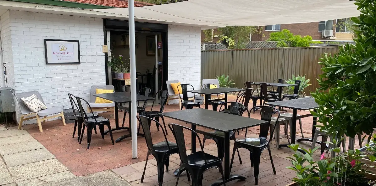 Loving Hut Perth outdoor courtyard with tables under a shade sail