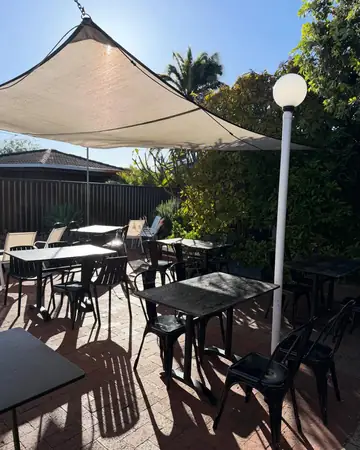 Sunny courtyard with tables under the shade sail